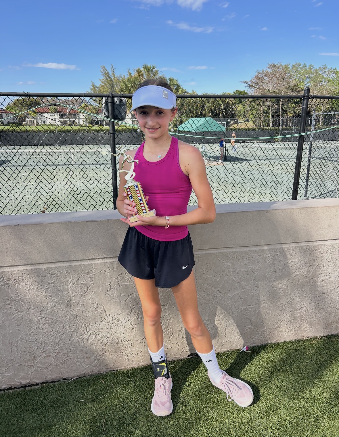 Junior tournament player holding a trophy
